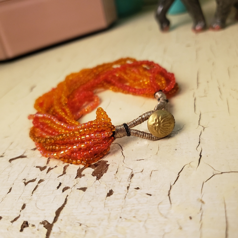 Orange beaded bracelet with gold detailed latch